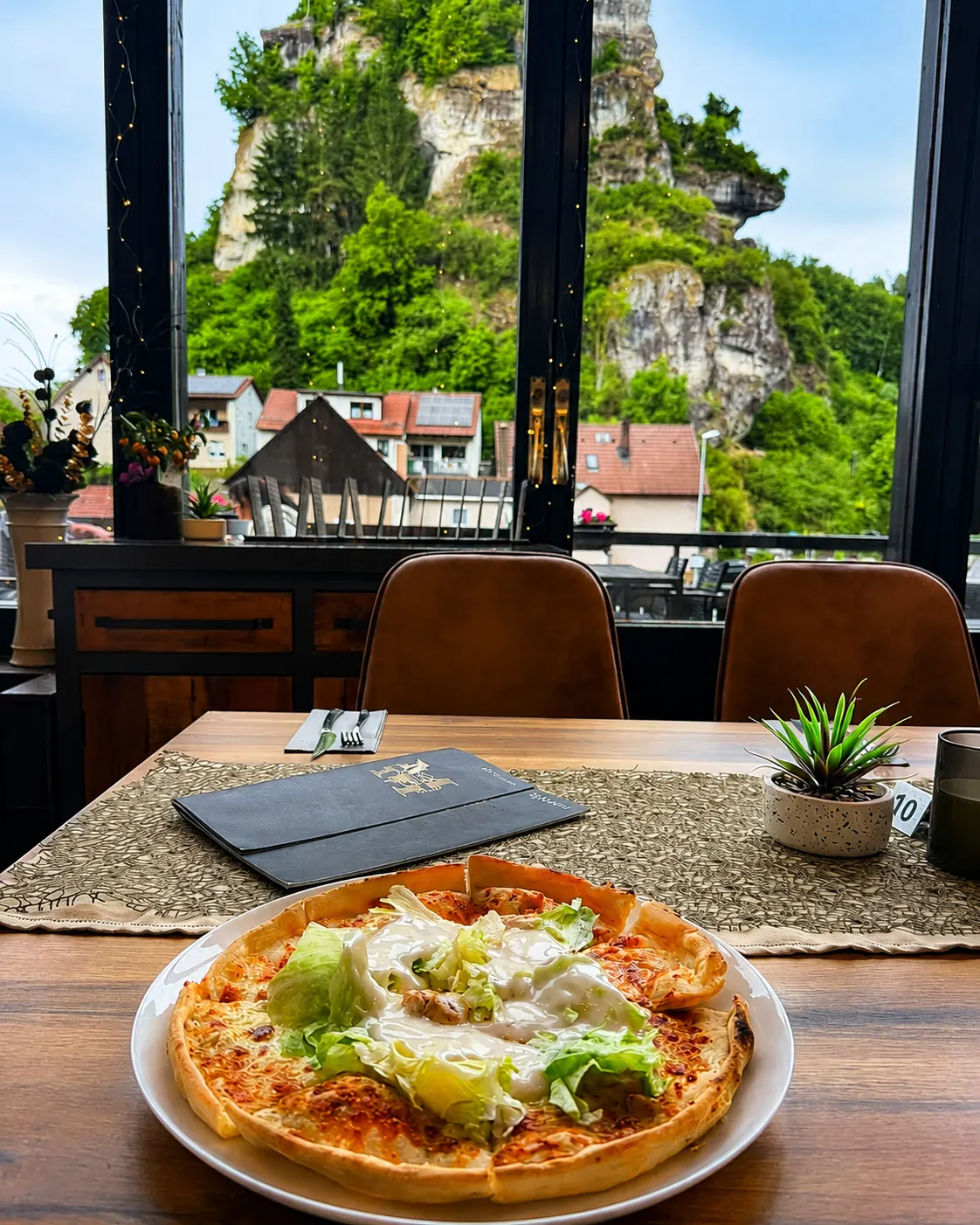Pizza mit Felsenblick durch das Panoramafenster