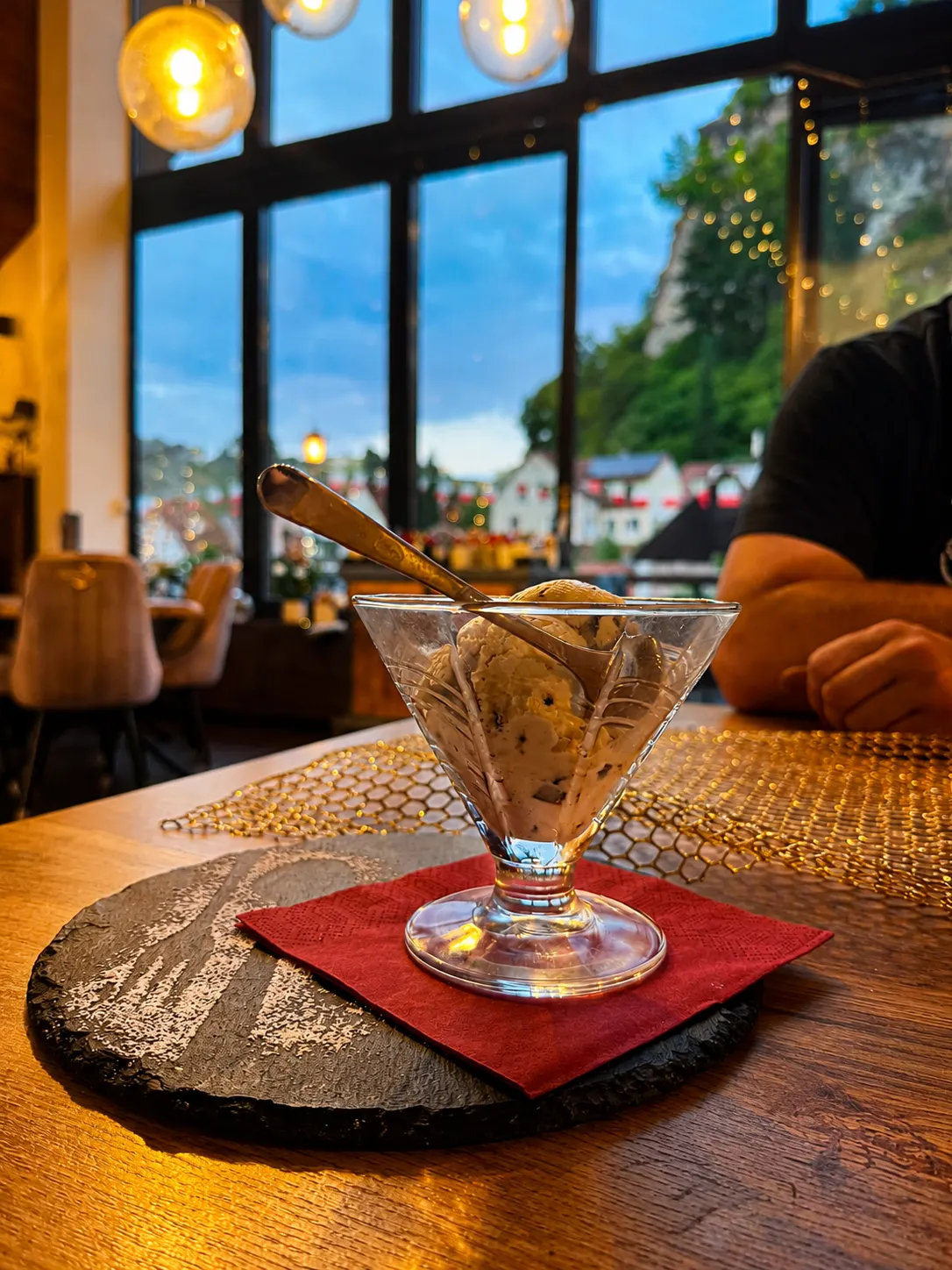 Eisbecher am Fensterplatz mit Blick auf den Pottensteiner Felsen in der Abenddämmerung