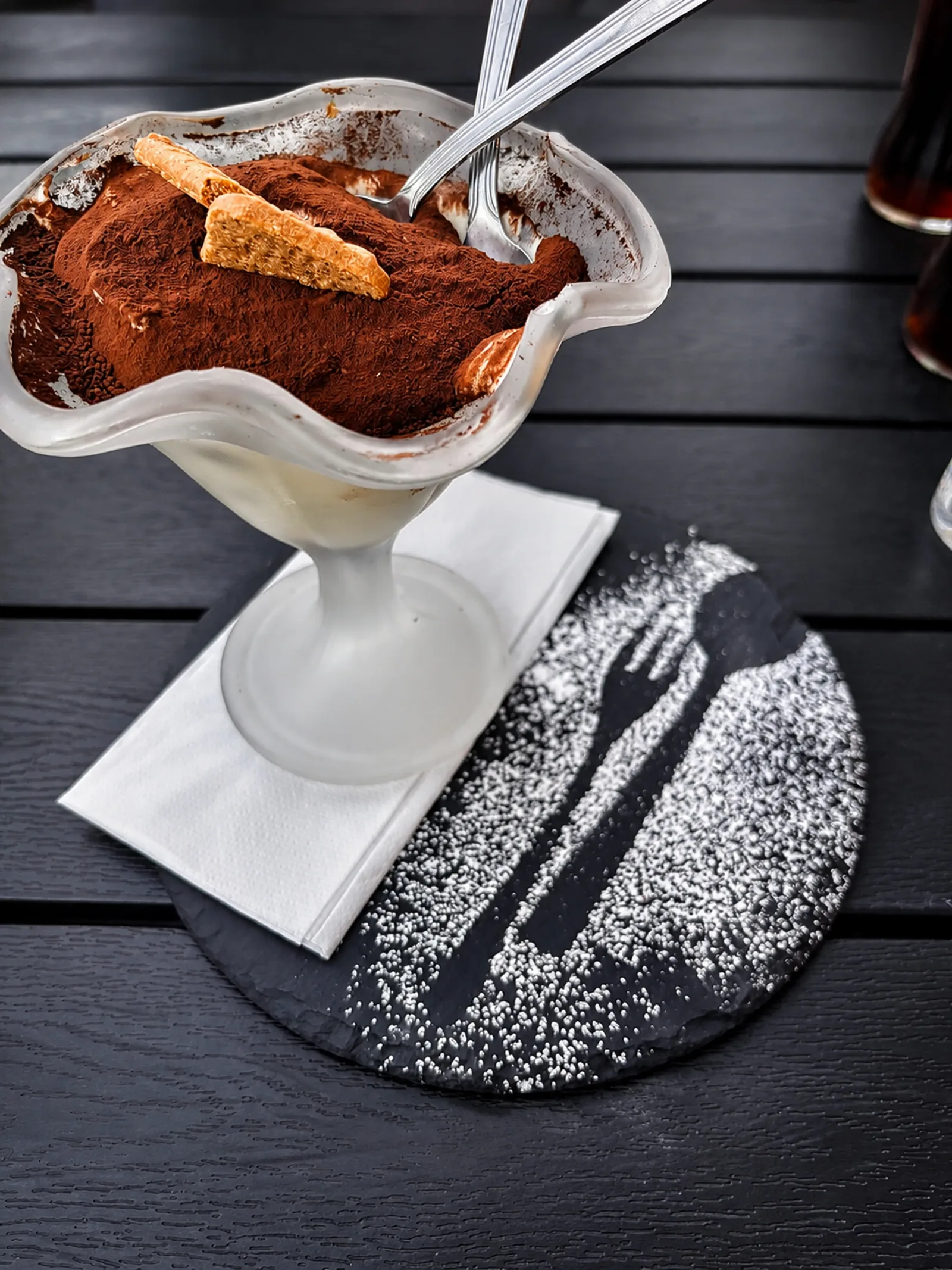 Tiramisu im Glas mit Kakao und Cantuccini auf Schieferplatte