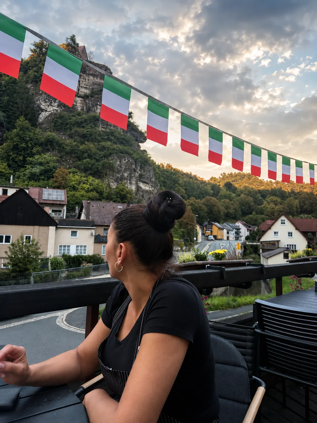 Gastgeberin auf der Terrasse mit italienischen Flaggen und Felsenblick