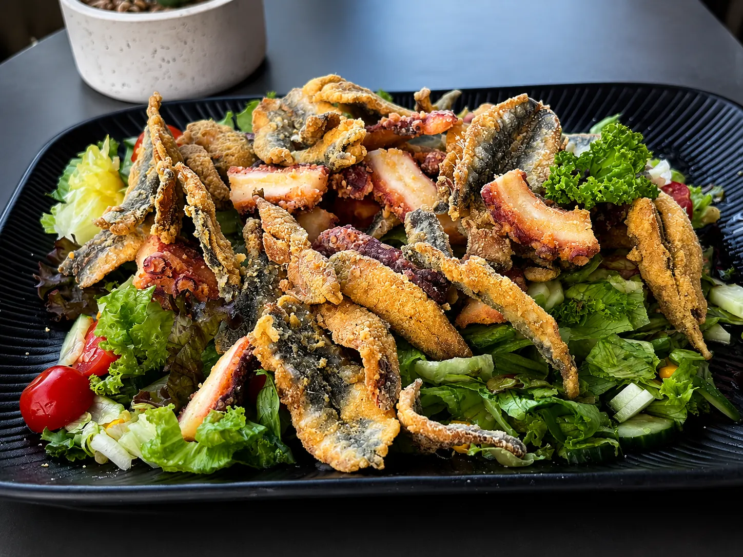 Frittierte Sardellen und Oktopus auf frischem Salat