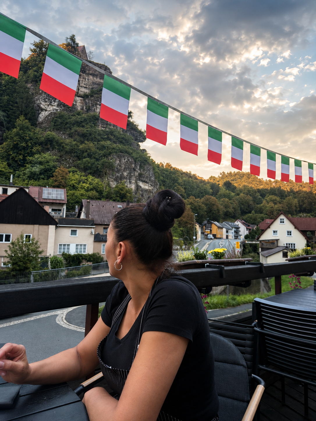 Gastgeberin auf der Terrasse mit italienischen Flaggen und Felsenblick