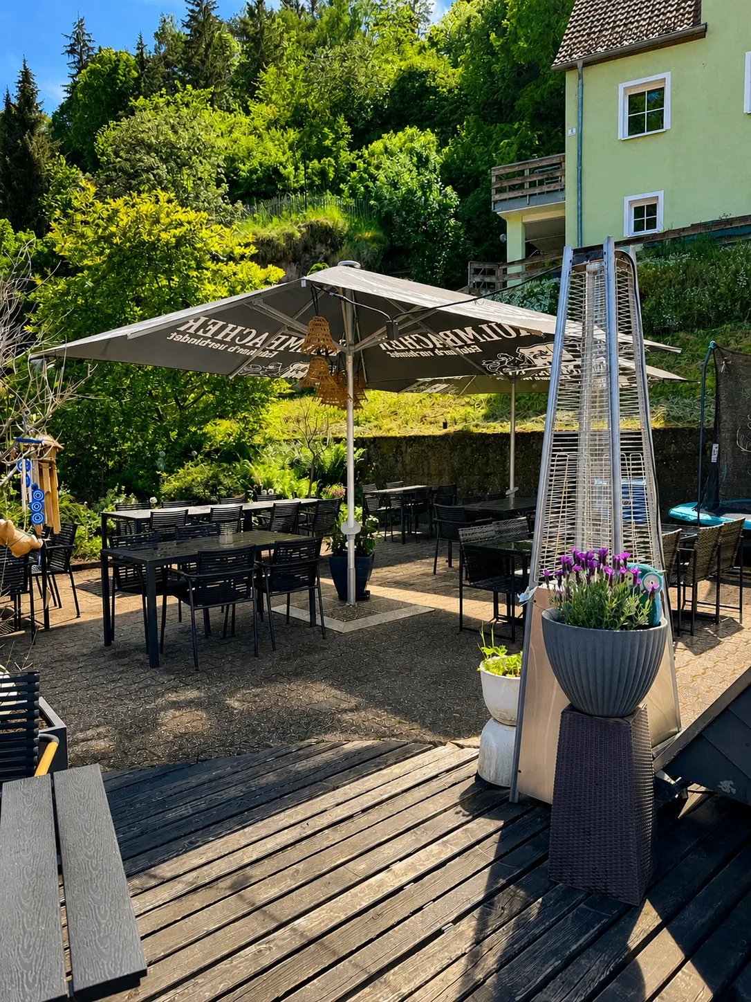 Biergarten des Restaurant Moena im Sonnenschein mit großem Sonnenschirm