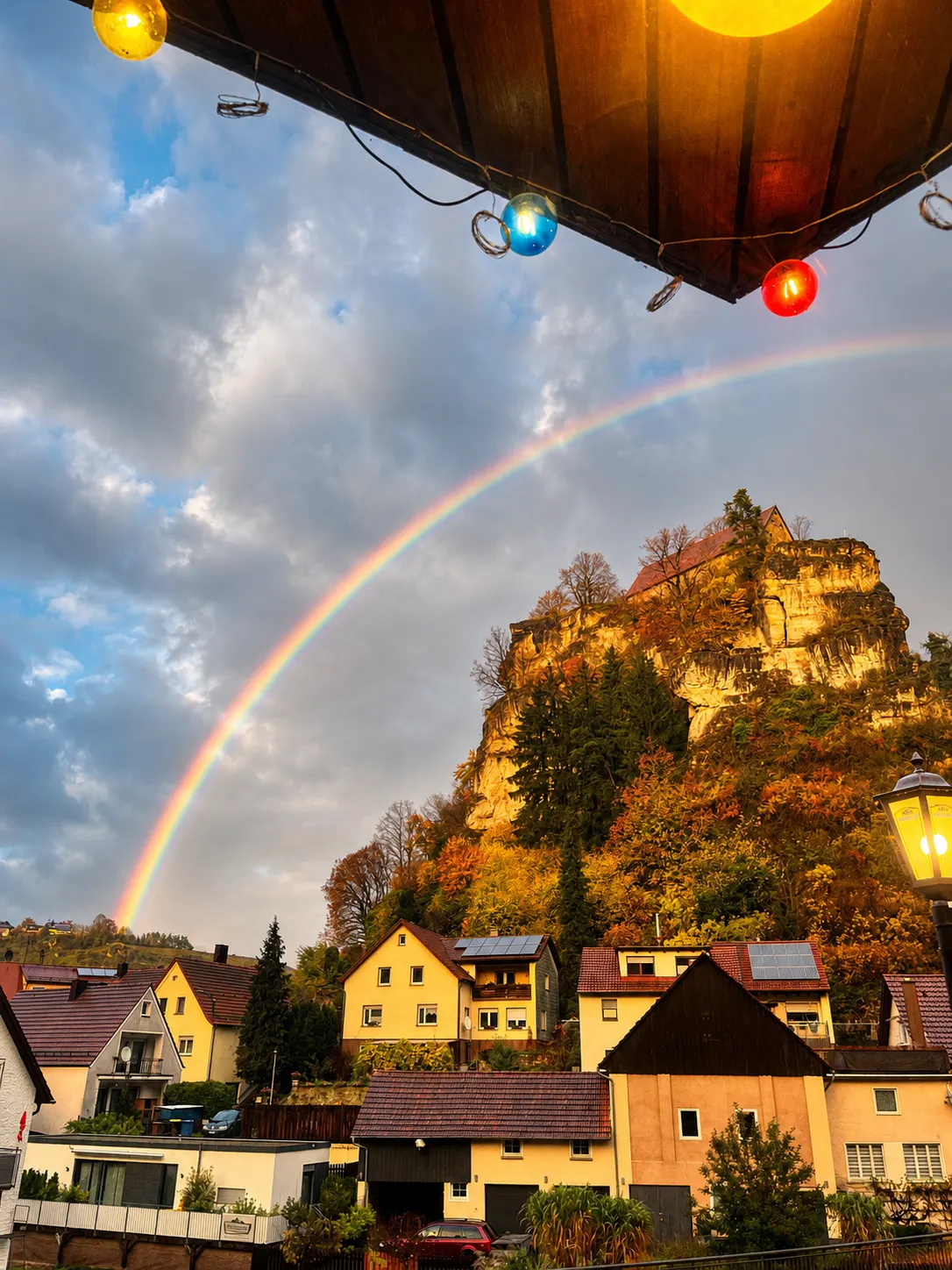 Regenbogen über Pottenstein mit Burg und Lichterkette von der Terrasse