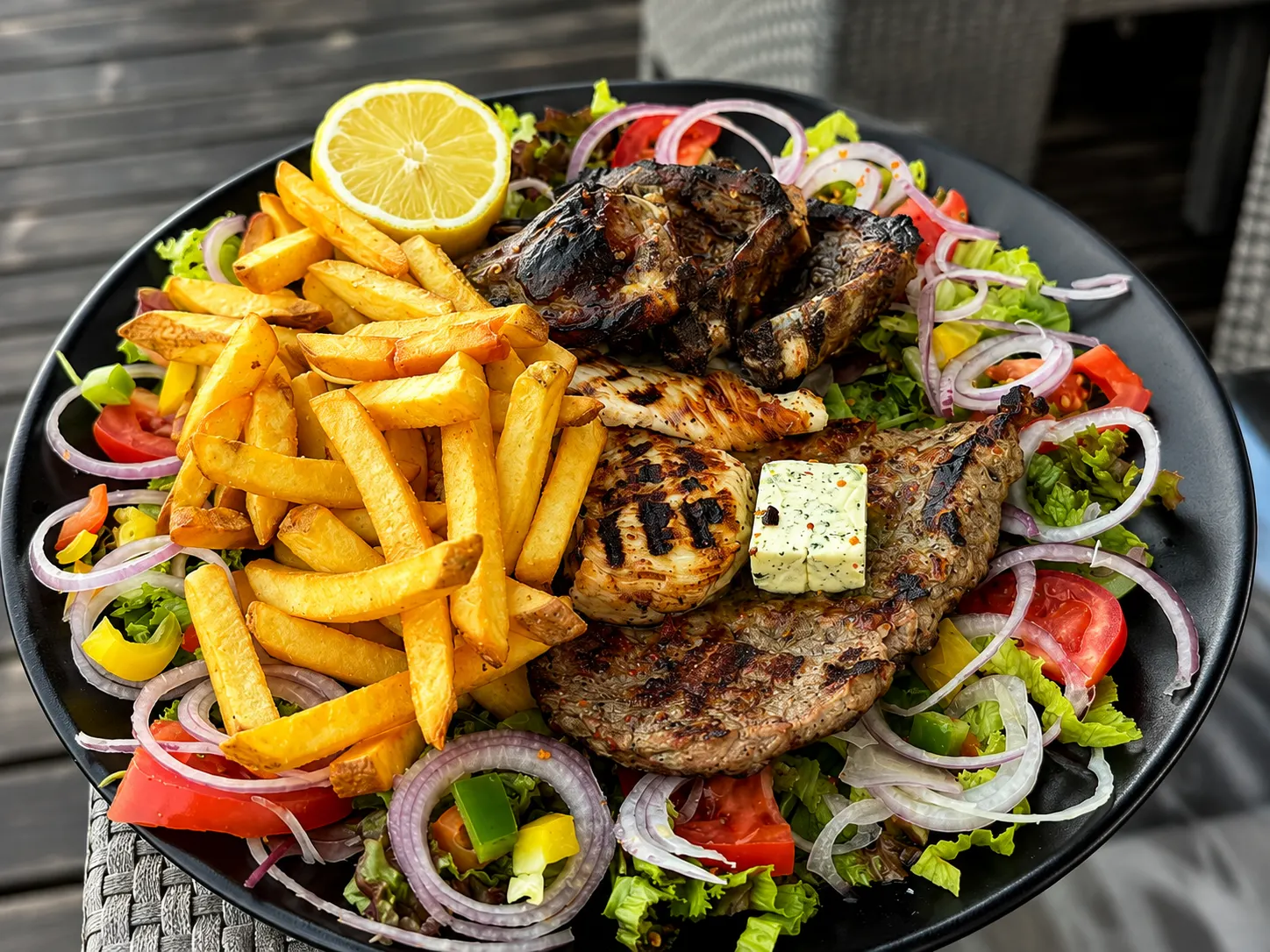 Großer Grillteller mit Steak, Hähnchen, Pommes und frischem Salat